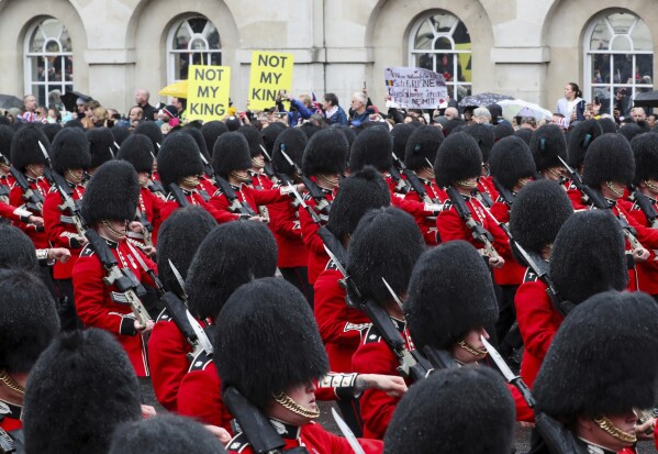 Grenadier Guards march past protesters demonstrate during the coronation ceremony of King Charles III at Westminster Abbey, London, Saturday May 6, 2023. (Violeta Santos Moura/Pool Photo via AP, File)